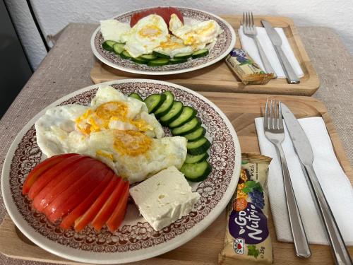 two plates of food with eggs and vegetables on a table at Kitka Hostel - Vratnica in Tetovo