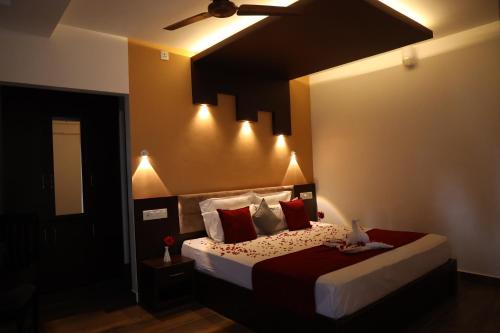 a bedroom with a bed with red and white pillows at Igloo Heritage Resorts in Idukki