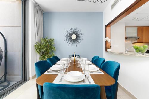 杜拜的住宿－Ultimate Stay / 4 Beds / Burj Khalifa View，一间带长桌和蓝色椅子的用餐室