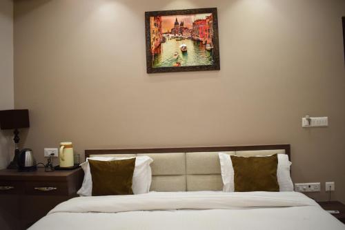 1 dormitorio con 1 cama con una foto en la pared en Hotel Singh Comfort Inn, en Gorakhpur