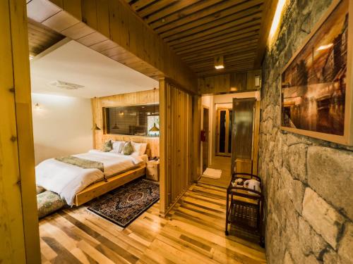 a bedroom with a bed and a stone wall at Famree Resort Hunza in Hunza Valley