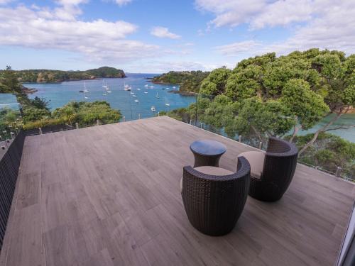 a balcony with chairs and a view of the water at Moonlit Knights - Tutukaka Holiday House in Tutukaka