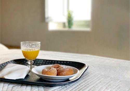 un vassoio con un piatto di ciambelle e un bicchiere di succo d'arancia di Castillo de Corvinos a Huesca