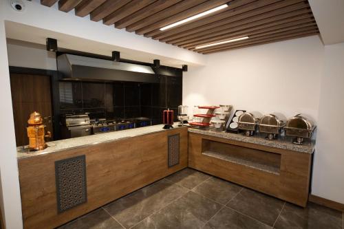 ÇaykaraにあるMayben Otel UZUNGÖLの鍋やフライパンが置かれたカウンターのあるキッチン