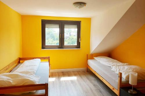 two beds in a room with yellow walls at 4 room apartment in Düren in Düren - Eifel
