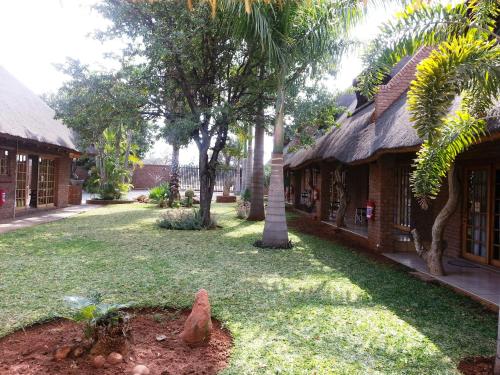 a courtyard of a building with a palm tree next to it at Siesta Guest House in Musina