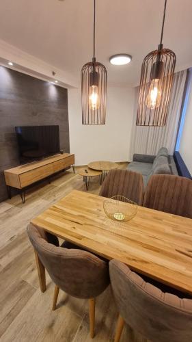 a living room with a wooden table and chairs at מגדלי המלכים בוטיק כנרת in Tiberias