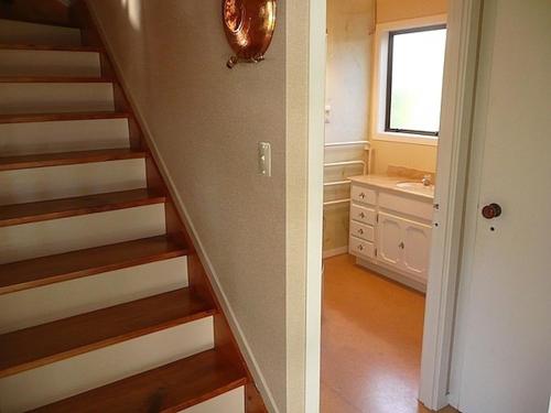 un bagno con scala e un bagno con lavandino di Cute Cottage - Cooks Beach Bach a Cooks Beach