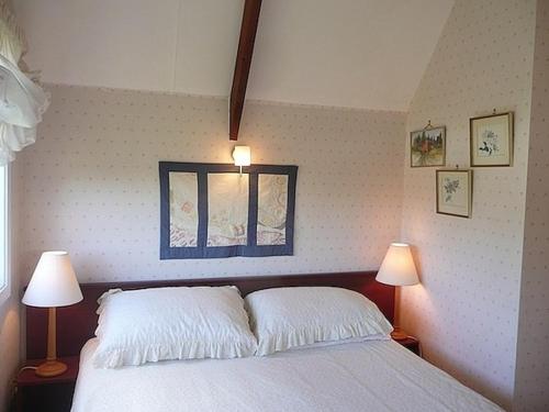 una camera da letto con un letto con due lampade e una finestra di Cute Cottage - Cooks Beach Bach a Cooks Beach