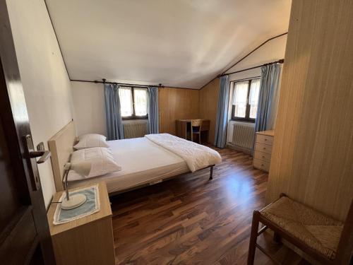 1 dormitorio pequeño con 1 cama y 2 ventanas en 050 Trilocale in centro, Pinzolo, en Pinzolo