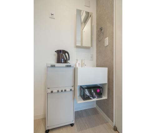 a kitchen with a white refrigerator in a room at ZAITO Tokyo Mukojima Hotel 押上駅徒歩七分ホテル in Tokyo