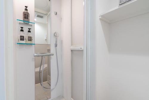 a shower in a bathroom with white walls at ZAITO Tokyo Mukojima Hotel 押上駅徒歩七分ホテル in Tokyo