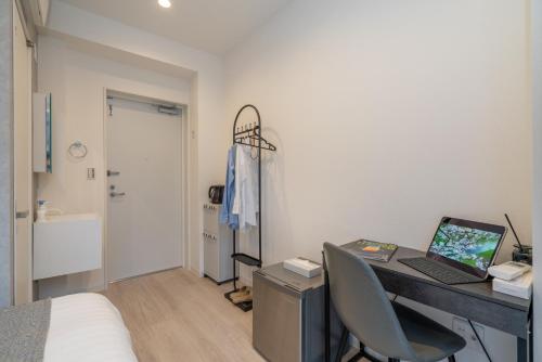 a bedroom with a desk with a laptop on it at ZAITO Tokyo Mukojima Hotel 押上駅徒歩七分ホテル in Tokyo