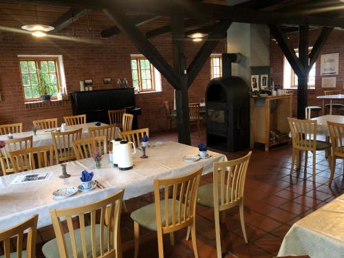 a dining room with a table and chairs and a fireplace at Skærum Mølle in Vemb