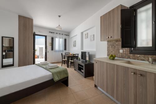 a bedroom with a bed and a kitchen with a sink at Lindos Olive Suites in Líndos