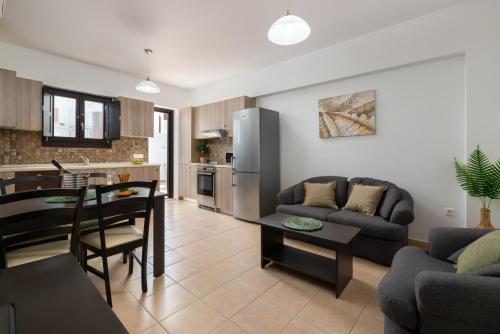 a kitchen and living room with a couch and a table at Lindos Olive Suites in Líndos