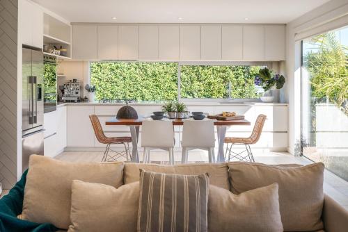 a kitchen and living room with a couch and a table at Moa Magic - Oneroa Holiday Home in Oneroa
