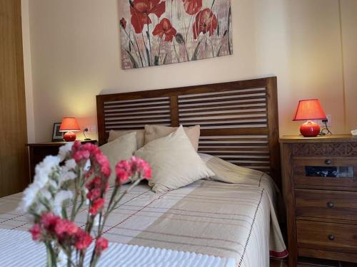 a bedroom with a bed with flowers and two lamps at Casa con Encanto,disfruta de su paz y tranquilidad in Adzaneta