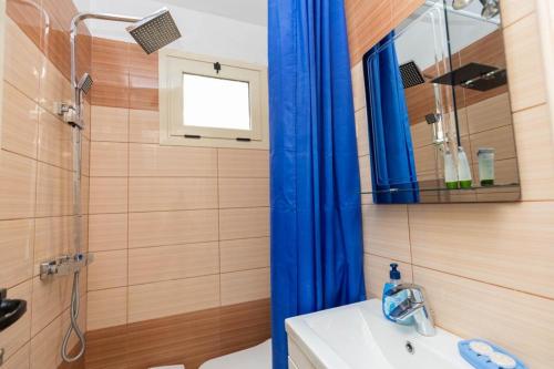 a bathroom with a blue shower curtain and a sink at PREMIER GUEST HOUSE in Vlorë