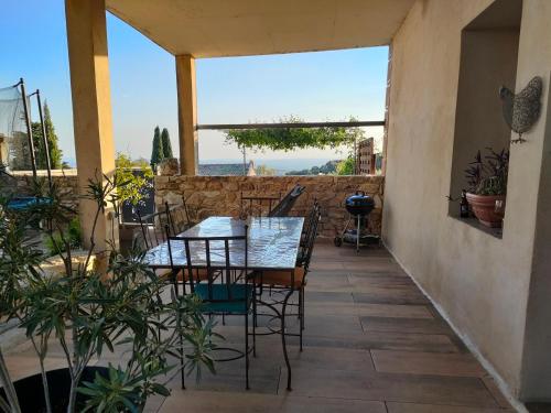 a table and chairs on a patio with a view at La maison d'Yvette - Gîte avec piscine, terrasse privée et vue in Le Barroux