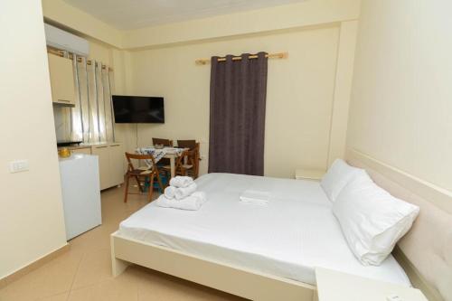 a bedroom with a bed with towels on it at PREMIER GUEST HOUSE in Vlorë