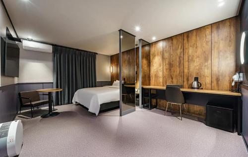 Brown-Dot Hotel Geomdan في انشيون: غرفة في الفندق مع سرير ومكتب