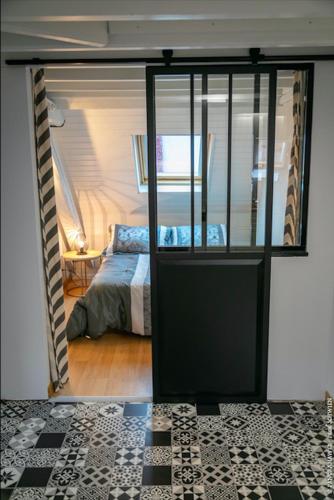 Cette chambre comprend un lit et une porte menant à une chambre. dans l'établissement Appartement Les Tournesols avec Climatisation, à Kaysersberg