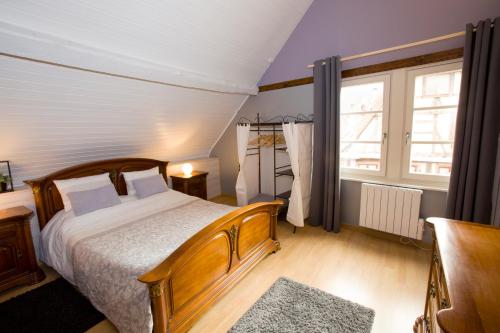 a bedroom with a large bed and a window at Appartement Les Tournesols avec Climatisation in Kaysersberg
