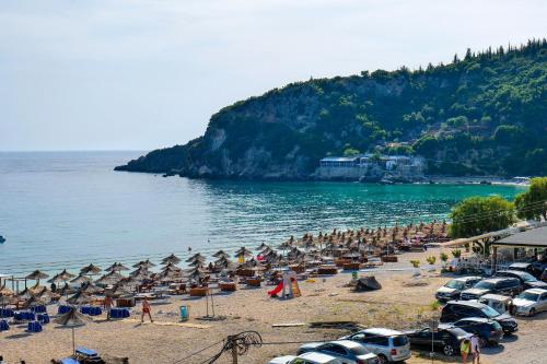 a beach with many umbrellas and cars on it at Alex & Sofi Hotel in Himare