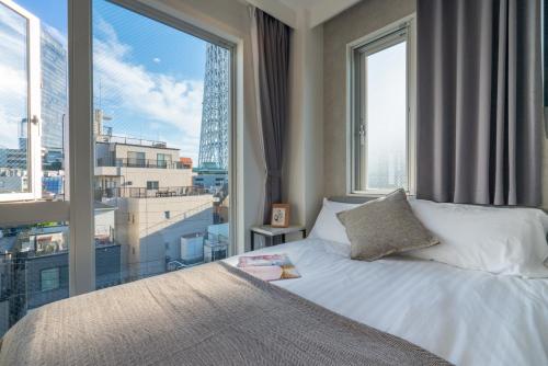 a bedroom with a bed and a large window at ZAITO Tokyo Mukojima Hotel 押上駅徒歩七分ホテル in Tokyo