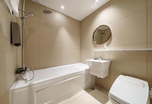 a bathroom with a tub and a toilet and a sink at Brown-Dot Hotel Geomdan in Incheon