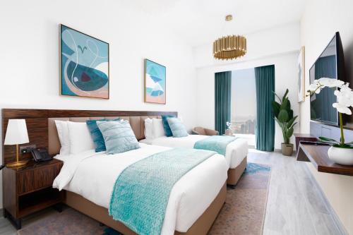 two beds in a hotel room with white walls at Ultimate Stay - Avani Palm Burj-AlArab View from the pool in Dubai