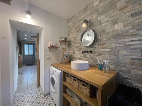 a bathroom with a sink and a washing machine at Le Jardin de Juliette in Gournay