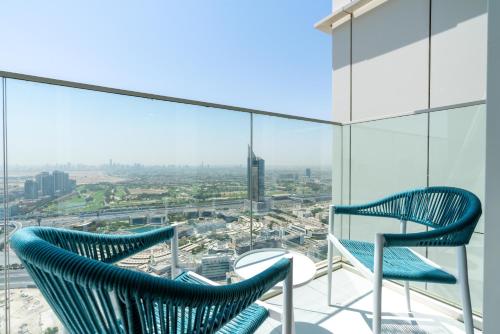two chairs on a balcony with a view of a city at Ultimate Stay Avani next to Palm Jumeirah in Dubai