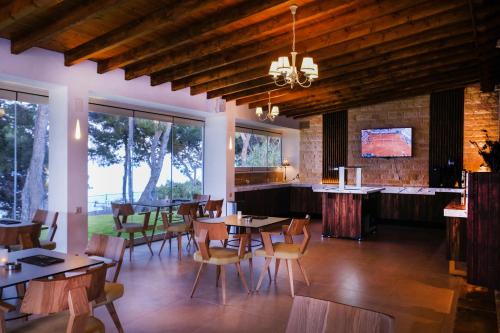 ein Restaurant mit Tischen und Stühlen und eine Bar in der Unterkunft Country Inn in Kallithea (Chalkidiki)