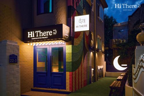 a building with a blue door and a sign on it at Hithere guesthouse in Seoul