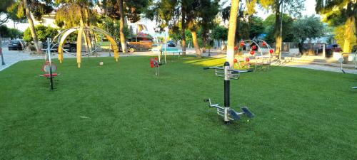 a park with a bunch of playground equipment in the grass at PiPi's House in Néa Artáki