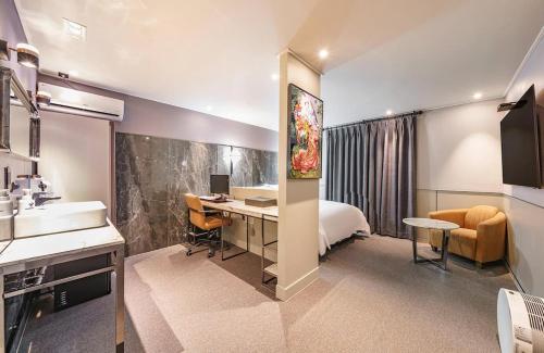 a hotel room with a bed and a desk with a computer at Brown-Dot Hotel Geomdan in Incheon
