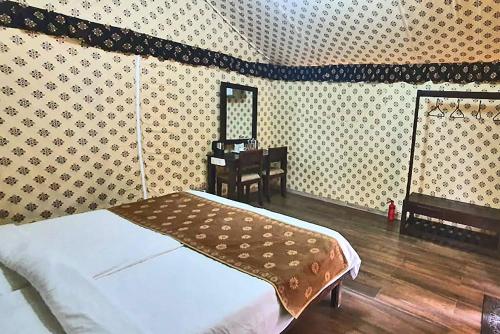 a bedroom with a bed and a table and a mirror at Praveg Tent City Narmada, Statue of Unity in Kevadia