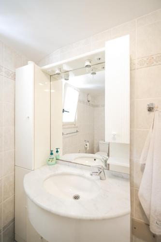 a white bathroom with a sink and a mirror at Two bedroom apartment in city center Igor in Zadar