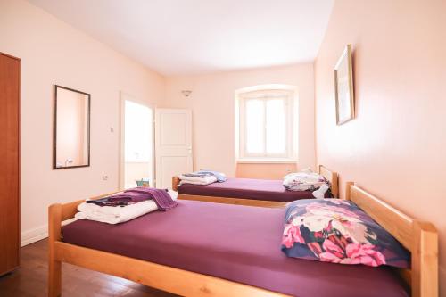 a bedroom with two beds with purple sheets at Two bedroom apartment in city center Igor in Zadar