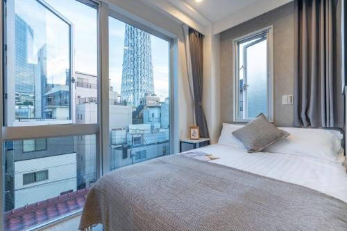 a bedroom with a bed and a large window at ZAITO Tokyo Mukojima Hotel 押上駅徒歩七分ホテル in Tokyo