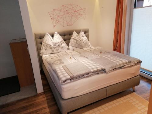a bedroom with a bed with white sheets and pillows at Sonnfeld Appartement in Sankt Veit im Pongau