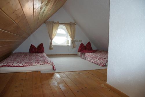 1 dormitorio en el ático con 2 camas y ventana en Schwalbennest Kaisitz, en Kaisitz