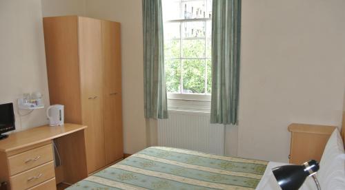 a bedroom with a bed and a window at European Hotel in London