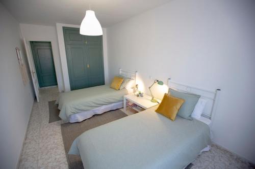 1 dormitorio con 2 camas y mesa con lámpara en Ebro Alojamiento VUT 47-314 en Arroyo de la Encomienda