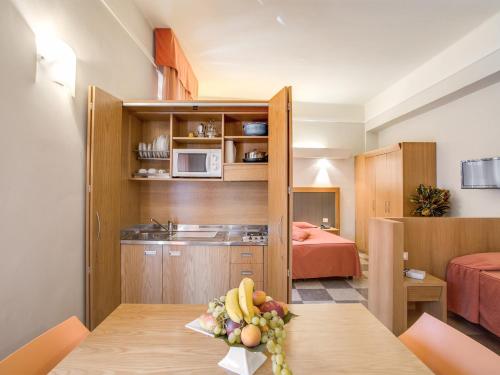 a room with a kitchen and a table with fruit on it at Hotel Delle Nazioni in Florence