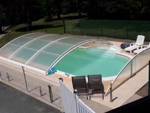 - une piscine entourée de 2 chaises et d'un sauna dans l'établissement Le logis de LANGE apt Les Aigrettes, à Saint-Hilaire-la-Palud