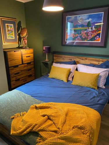 格地尼亞的住宿－Trendy Modern Tower Apartment with Private Parking Space，一间卧室配有一张带蓝色床单和黄色枕头的床。