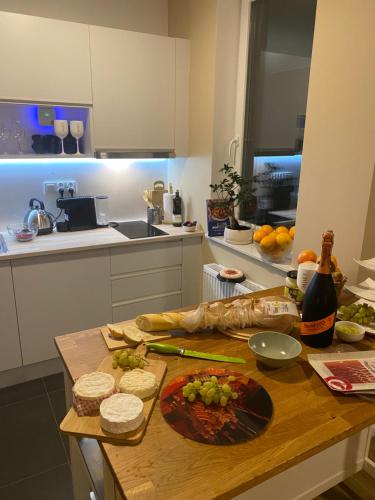 a kitchen with a table with food and bottles of wine at Trendy Modern Tower Apartment with Private Parking Space in Gdynia